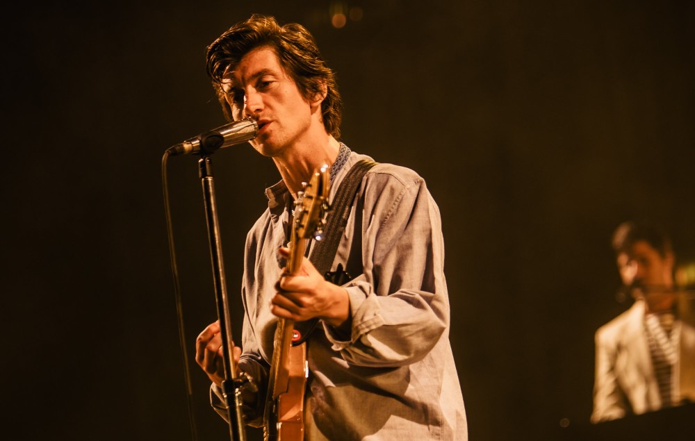 Alex Turner of Arctic Monkeys playing guitar at a festival