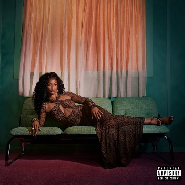 Image may contain: Ari Lennox, Adult, Person, Couch, Furniture, Curly Hair, Hair, Performer, Solo Performance, and Sitting